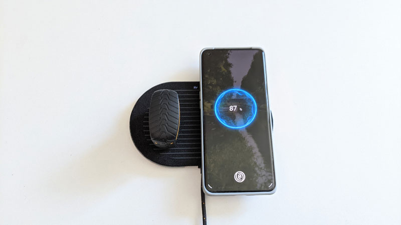 Le boîtier des Klipsch T5 II True Wireless ANC McLaren Edition et un smartphone sur le socle de recharge sans fil, 2021, Ph. Moctar KANE.
